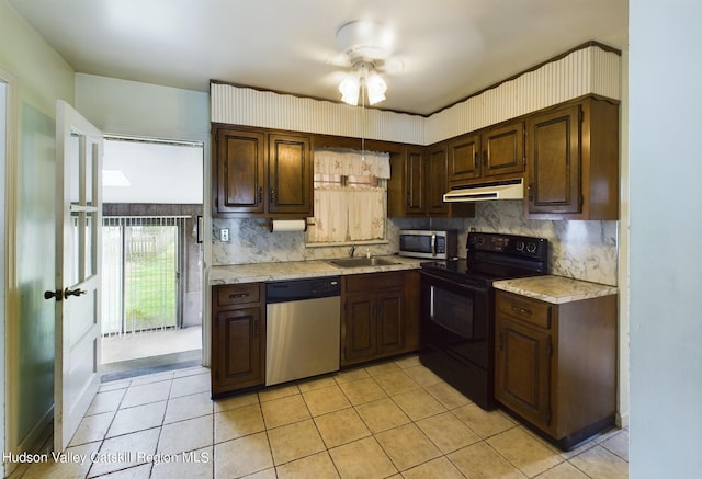 kitchen with dark brown cabinets, appliances with stainless steel finishes, sink, backsplash, and light tile patterned floors