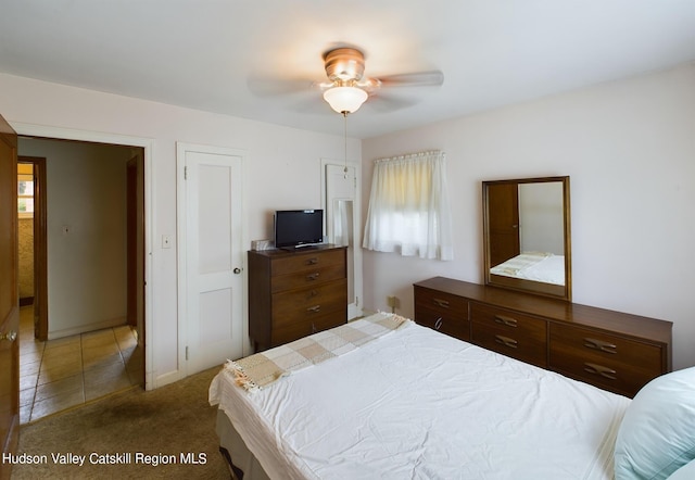 carpeted bedroom featuring ceiling fan and multiple windows