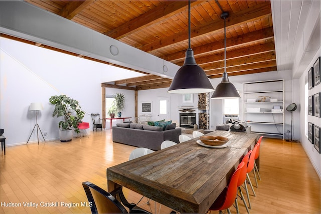 dining area with beamed ceiling, wooden ceiling, and a fireplace