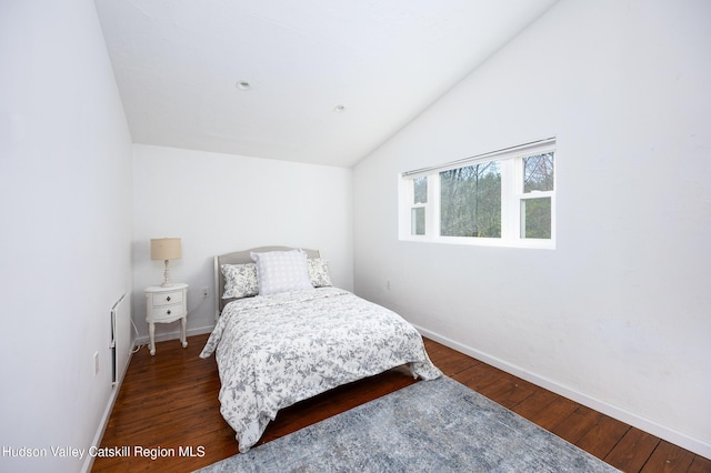 bedroom featuring baseboards, lofted ceiling, and dark wood-style floors