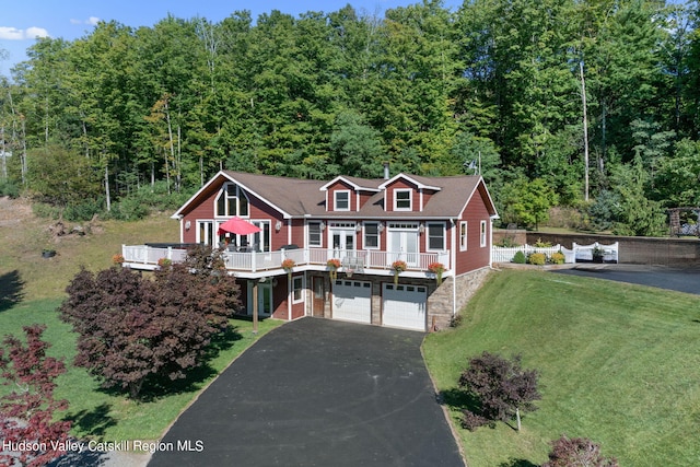 view of front of house featuring a garage, a wooden deck, and a front yard