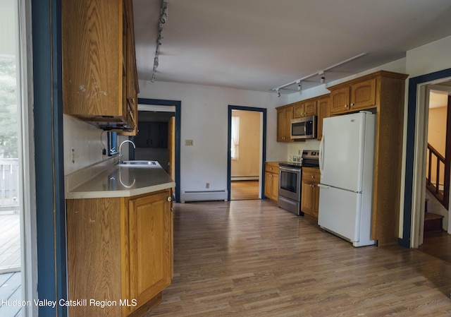 50 Payn Ave, Chatham, NY 12037 - kitchen with track lighting, appliances with stainless steel finishes, a baseboard heating unit, and wood finished floors