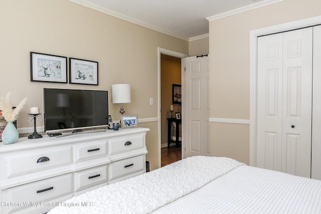 bedroom with crown molding, wood finished floors, and a closet