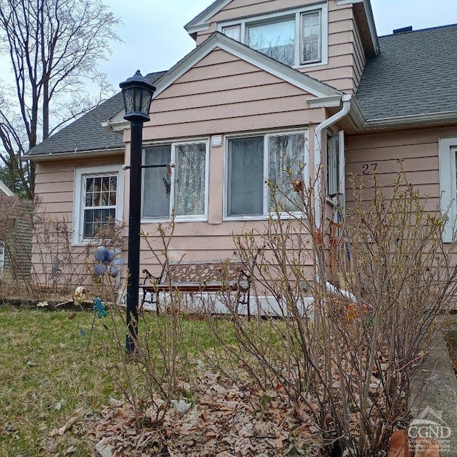 view of side of property featuring roof with shingles