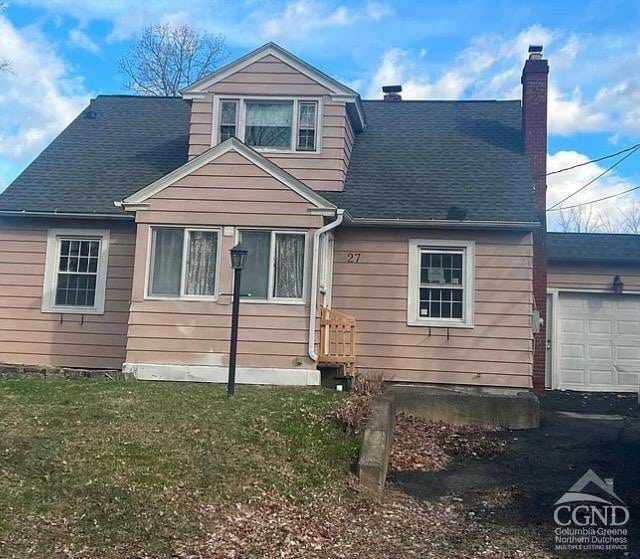 view of front of house with a shingled roof, a garage, a chimney, a front lawn, and asphalt driveway