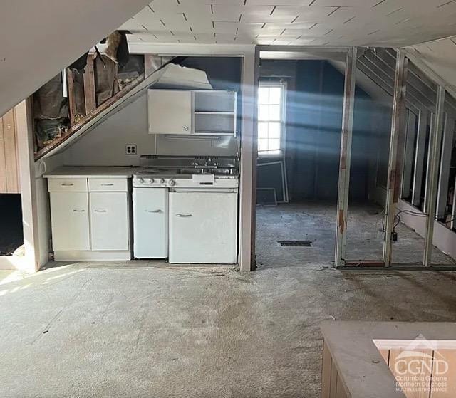 kitchen with white cabinets and lofted ceiling