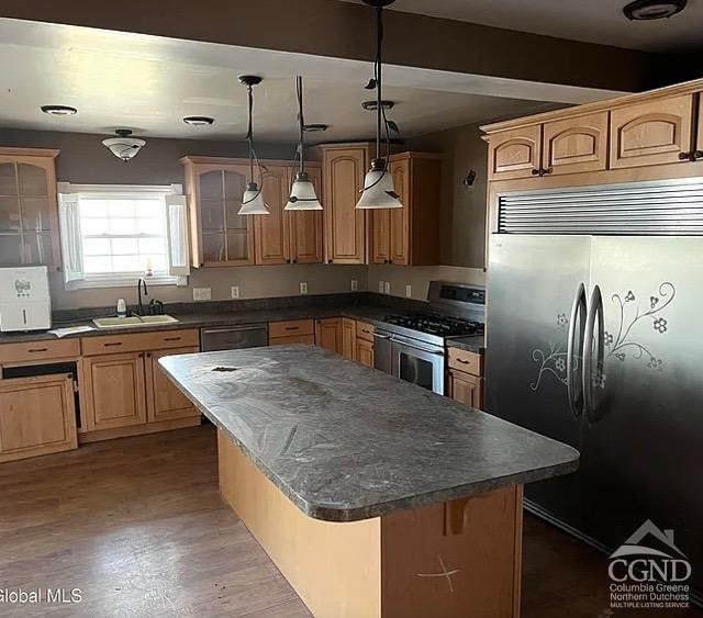 kitchen with built in refrigerator, stainless steel gas stove, a sink, dishwashing machine, and dark countertops