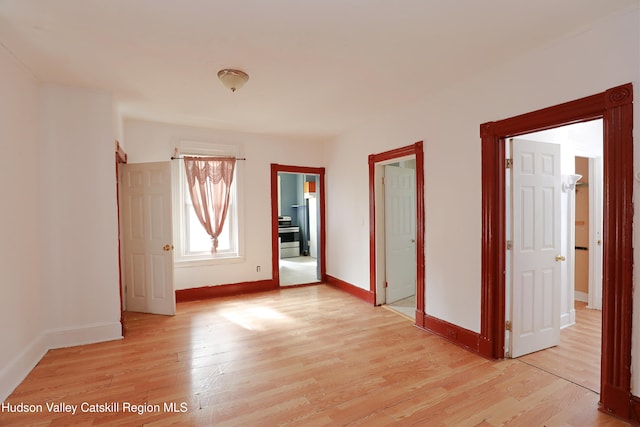 unfurnished room featuring light wood-style floors and baseboards