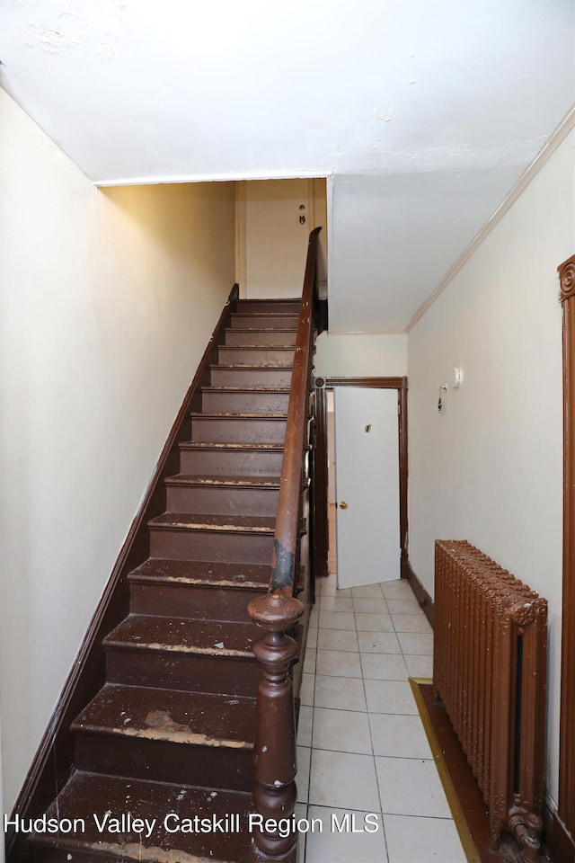 staircase featuring tile patterned floors, radiator, and crown molding
