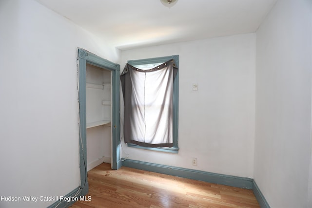 unfurnished room with wood finished floors and baseboards