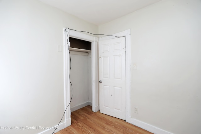 unfurnished bedroom with baseboards and light wood-style floors