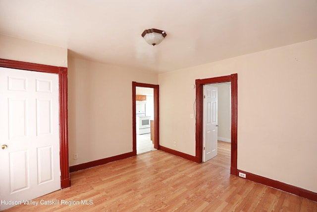 unfurnished room with light wood-style floors and baseboards