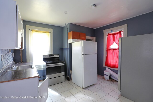 kitchen with a sink, light tile patterned floors, tasteful backsplash, and stainless steel appliances