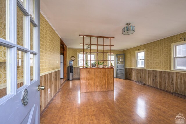 2 W Marie St, Hudson, NY 12534 - kitchen featuring freestanding refrigerator, wainscoting, wood finished floors, brown cabinets, and wallpapered walls