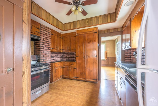 2 W Marie St, Hudson, NY 12534 - kitchen with stainless steel appliances, under cabinet range hood, brown cabinets, ceiling fan, and dark countertops