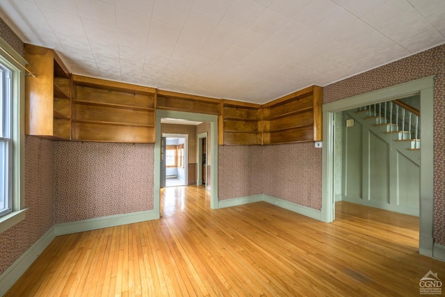 2 W Marie St, Hudson, NY 12534 - unfurnished room with wallpapered walls, light wood-style floors, baseboards, and stairway