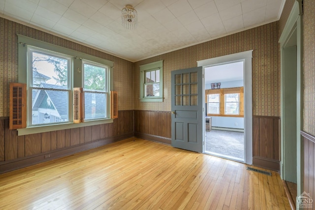 2 W Marie St, Hudson, NY 12534 - unfurnished room featuring wallpapered walls, light wood finished floors, healthy amount of natural light, ornamental molding, and a wainscoted wall