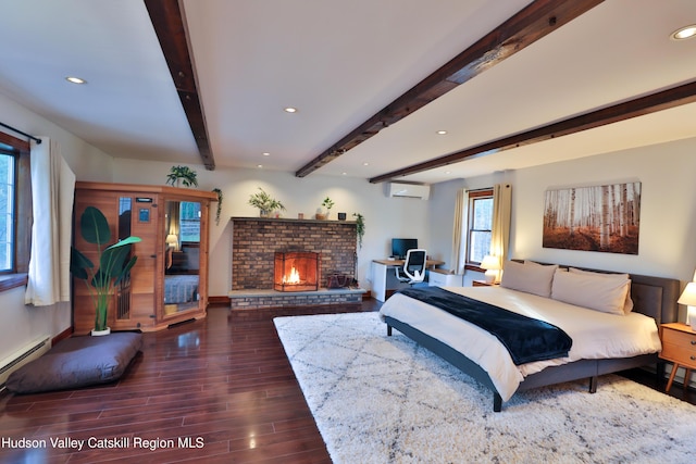 bedroom with beam ceiling, a wall mounted AC, a baseboard heating unit, and a brick fireplace