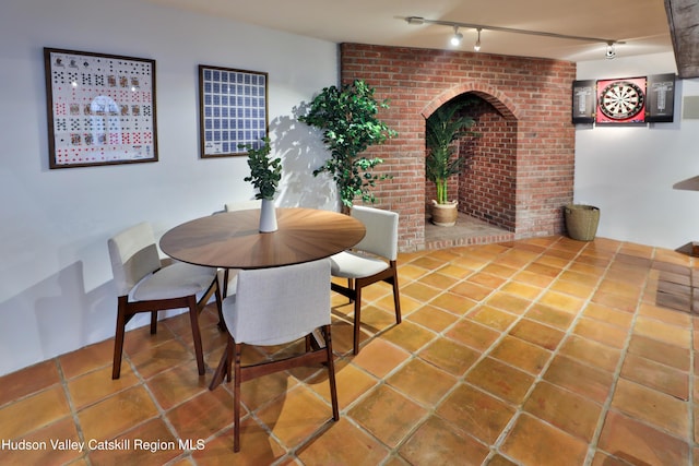 tiled dining space featuring track lighting