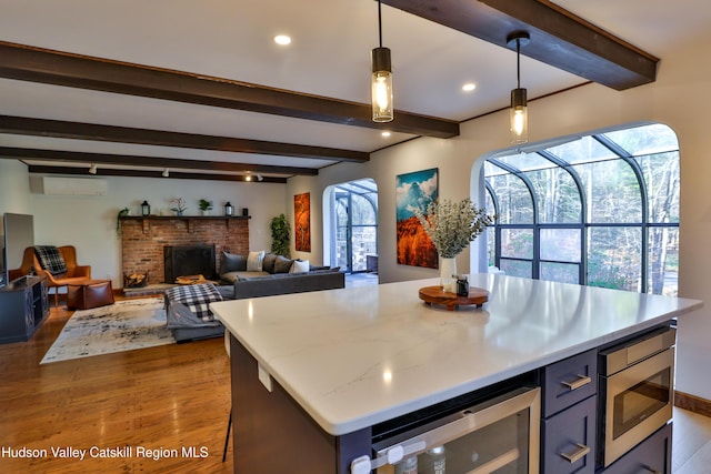 kitchen with dark hardwood / wood-style flooring, beam ceiling, hanging light fixtures, wine cooler, and stainless steel microwave