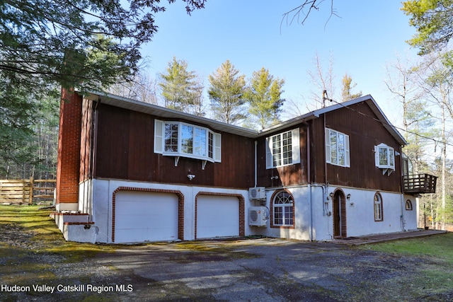 view of property exterior featuring ac unit and a garage