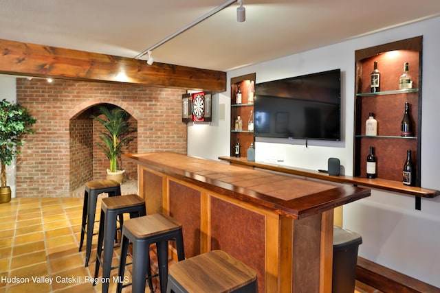 bar with rail lighting and brick wall