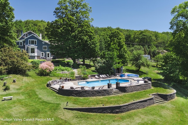 view of pool with a lawn