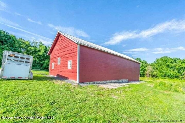 view of outbuilding featuring a lawn