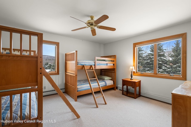 carpeted bedroom with ceiling fan, baseboard heating, and multiple windows