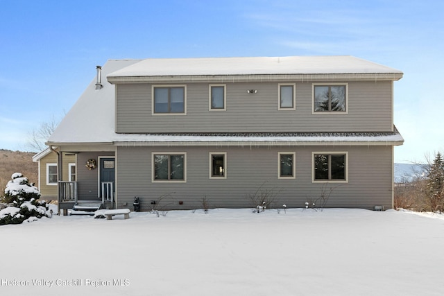 view of snow covered back of property