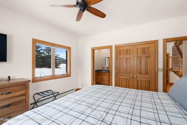 bedroom featuring a closet, a baseboard heating unit, and ceiling fan