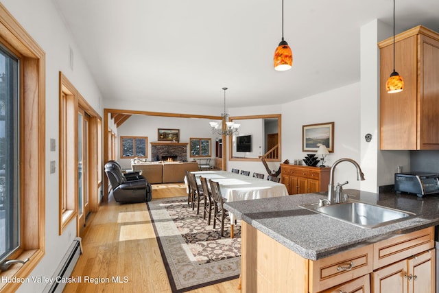 kitchen with sink, hanging light fixtures, light hardwood / wood-style flooring, light brown cabinetry, and a chandelier