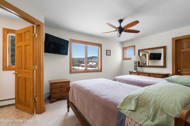 carpeted bedroom with ceiling fan and baseboard heating