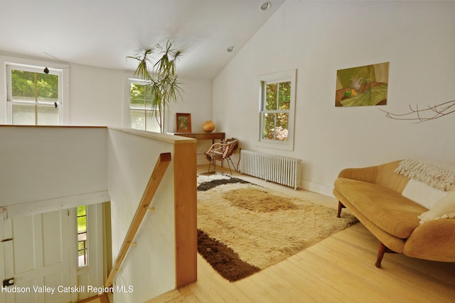 1130 Sawkill Rd, Kingston, NY 12401 - living area with radiator heating unit, wood finished floors, vaulted ceiling, and an upstairs landing