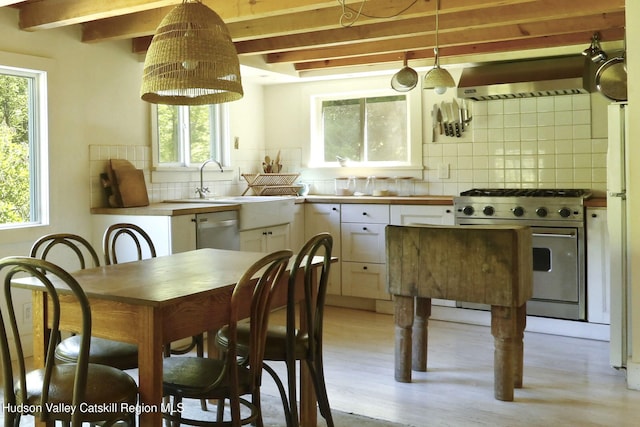 1130 Sawkill Rd, Kingston, NY 12401 - kitchen with appliances with stainless steel finishes, wall chimney exhaust hood, beamed ceiling, backsplash, and white cabinets
