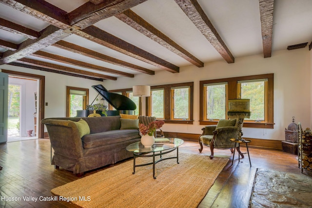 living area featuring hardwood / wood-style floors, beam ceiling, visible vents, and baseboards