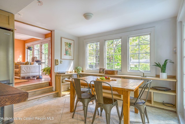 dining area with light tile patterned floors and a healthy amount of sunlight