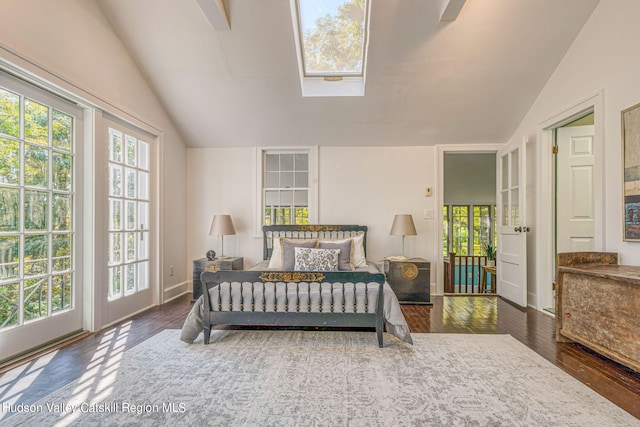 bedroom with vaulted ceiling with skylight, multiple windows, and wood finished floors