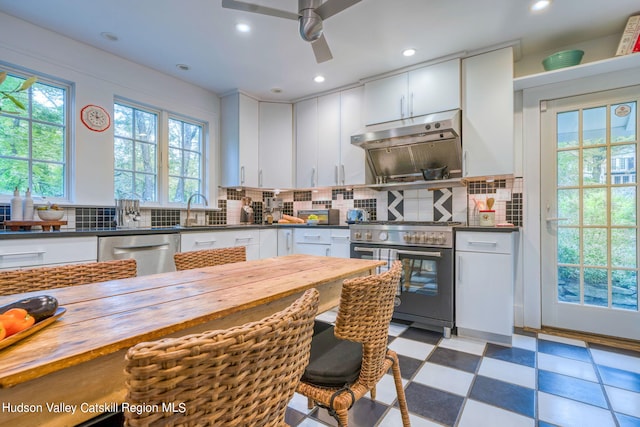 kitchen with ceiling fan, stainless steel appliances, wood counters, white cabinetry, and tile patterned floors