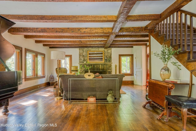 living room featuring beam ceiling, stairway, baseboards, and hardwood / wood-style floors