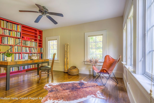 living area with hardwood / wood-style floors, baseboards, a wealth of natural light, and ceiling fan
