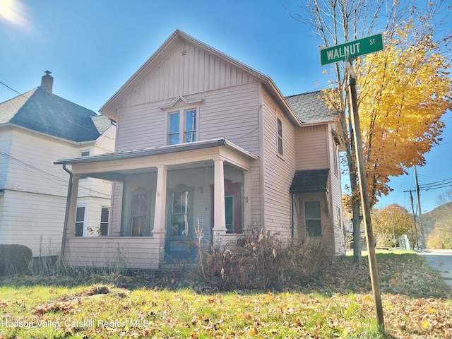 view of front facade featuring covered porch and a front lawn