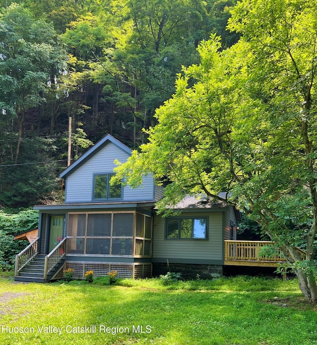 36 Rodney St, Kingston, NY 12401 - rear view of property featuring a sunroom, a wooden deck, a lawn, and a forest view