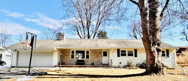 single story home with stone siding, driveway, a chimney, and an attached garage