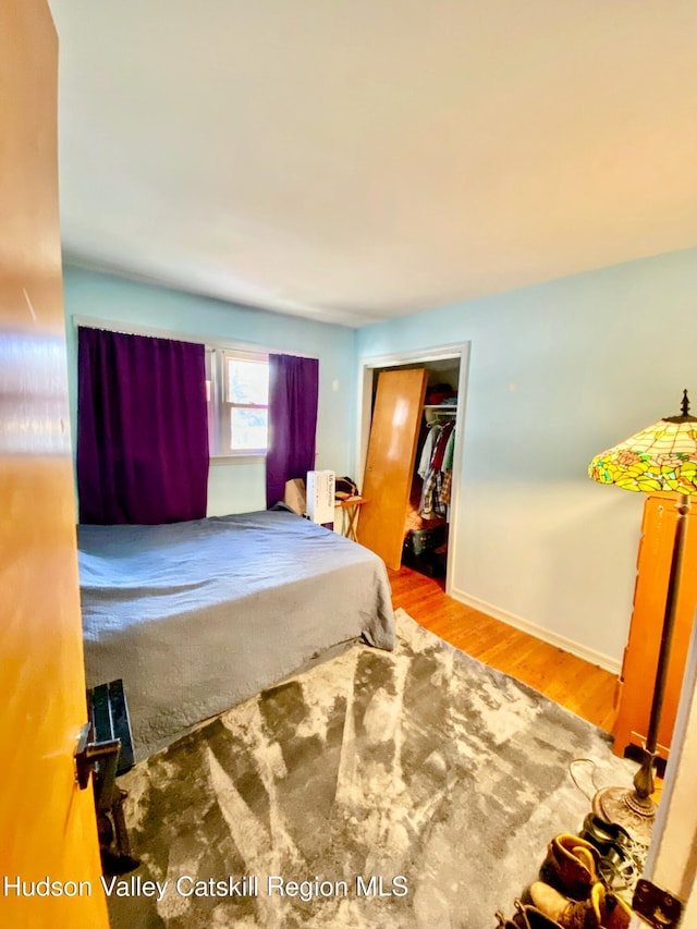 bedroom featuring a closet, baseboards, and wood finished floors
