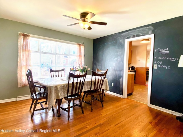 dining area with baseboard heating, ceiling fan, light wood-style flooring, and baseboards