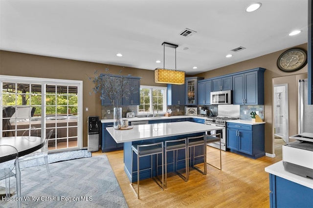10 Sutton Ln, Goshen, NY 10924 - kitchen featuring appliances with stainless steel finishes, blue cabinetry, light countertops, decorative backsplash, and recessed lighting