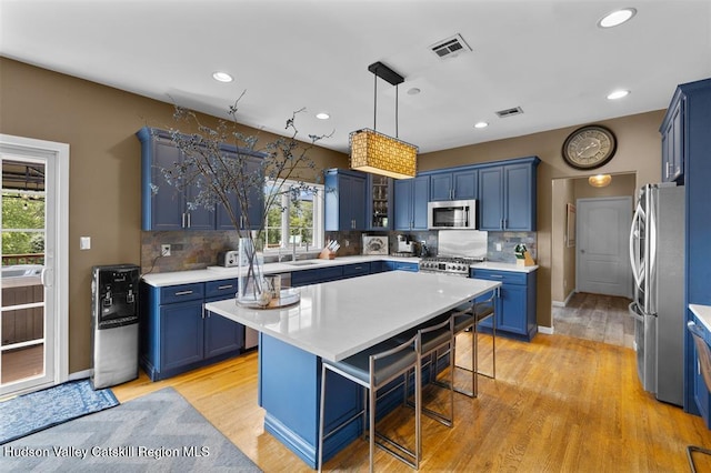10 Sutton Ln, Goshen, NY 10924 - kitchen featuring blue cabinetry, appliances with stainless steel finishes, healthy amount of natural light, light countertops, and recessed lighting