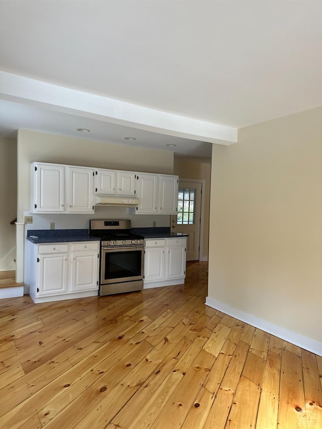 477 Fog Hill Rd, Austerlitz, NY 12017 - kitchen featuring stainless steel range oven, under cabinet range hood, light wood-type flooring, white cabinetry, and beamed ceiling