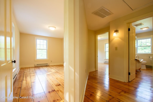 477 Fog Hill Rd, Austerlitz, NY 12017 - hallway featuring baseboard heating, light wood-type flooring, and healthy amount of natural light